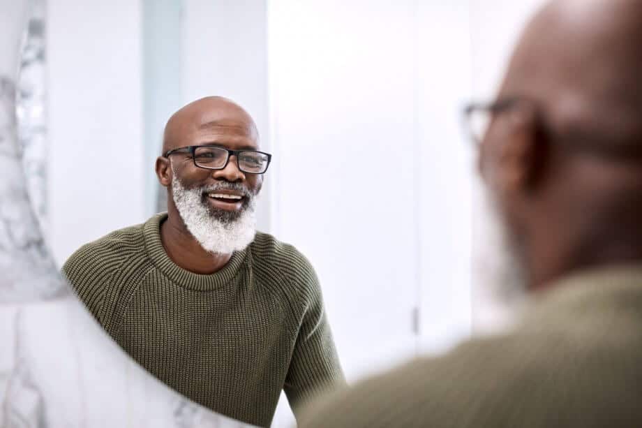 Mature smiling man in mirror 920x613
